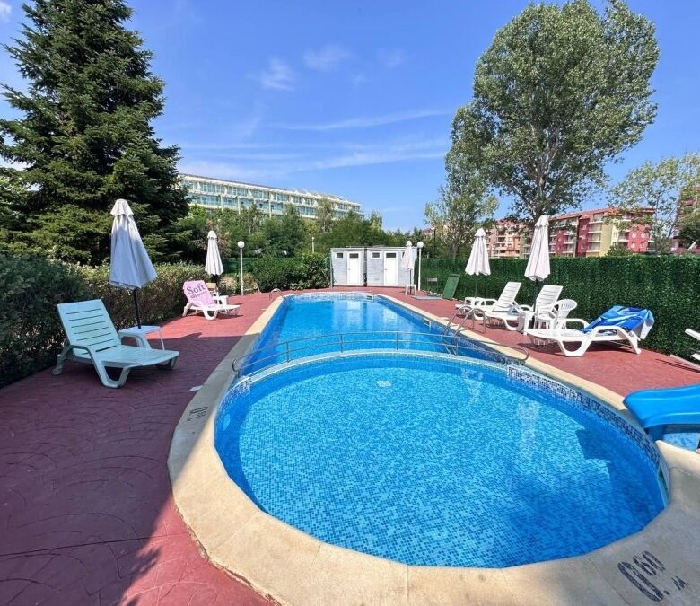 Beautiful outdoor pool area at Robinson Gardens with sun loungers and umbrellas in Sunny Beach.