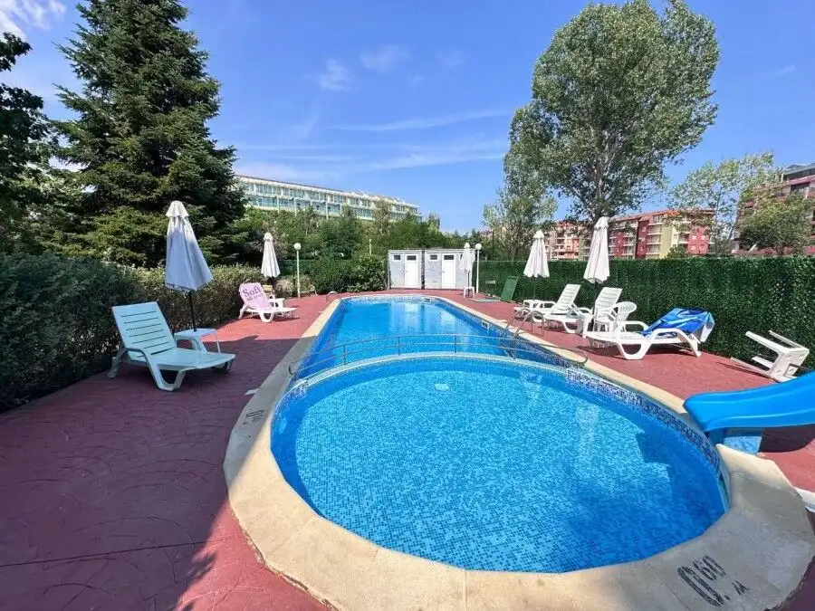 Beautiful outdoor pool area at Robinson Gardens with sun loungers and umbrellas in Sunny Beach.
