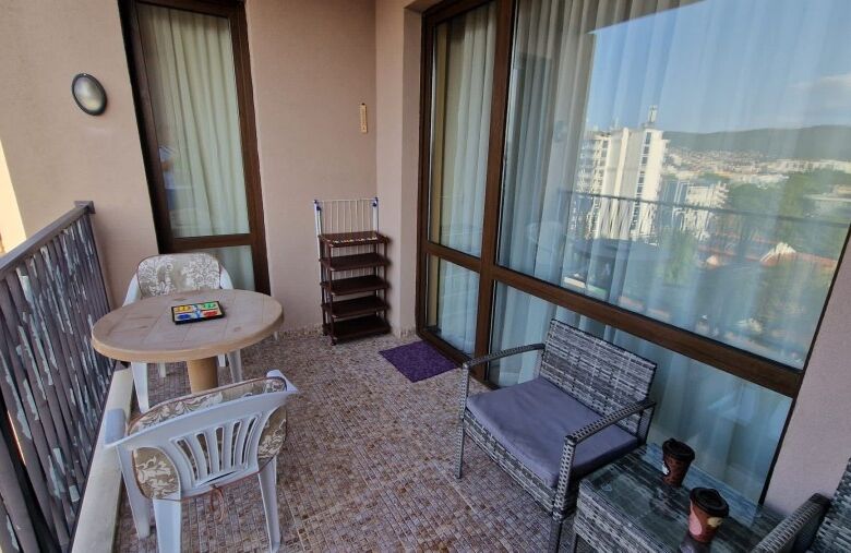 Balcony with outdoor seating and panoramic city views in a high-rise apartment.