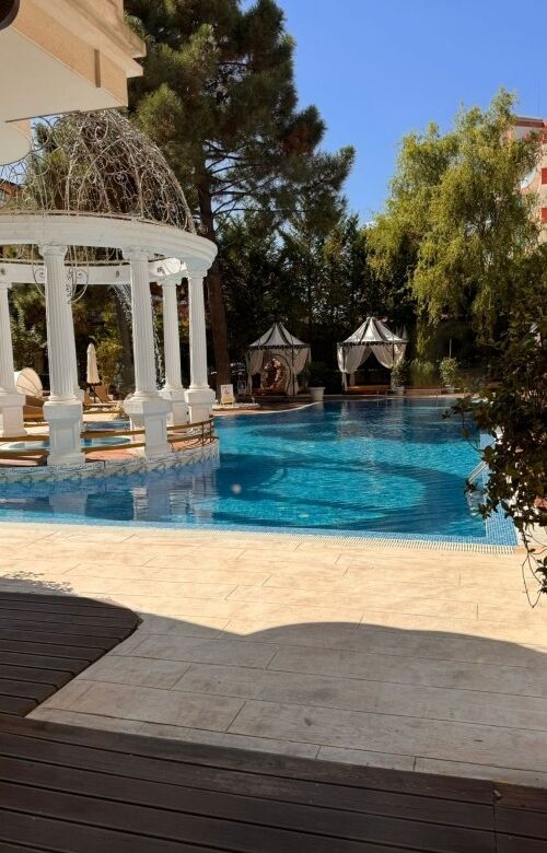 Outdoor swimming pool with gazebo and lush greenery at Harmony Palace, Sunny Beach.