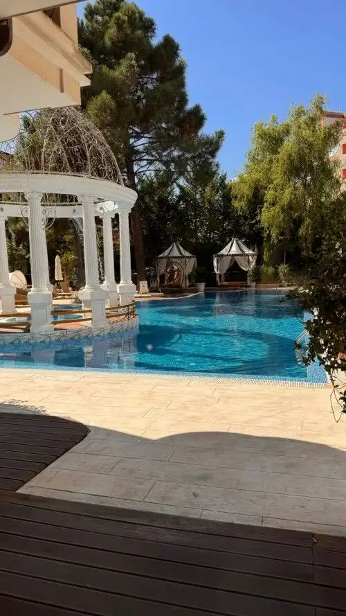 Outdoor swimming pool with gazebo and lush greenery at Harmony Palace, Sunny Beach.