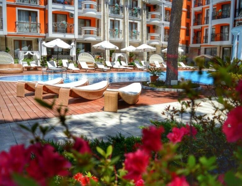 Pool area with sun loungers and umbrellas at Harmony Palace, Sunny Beach.