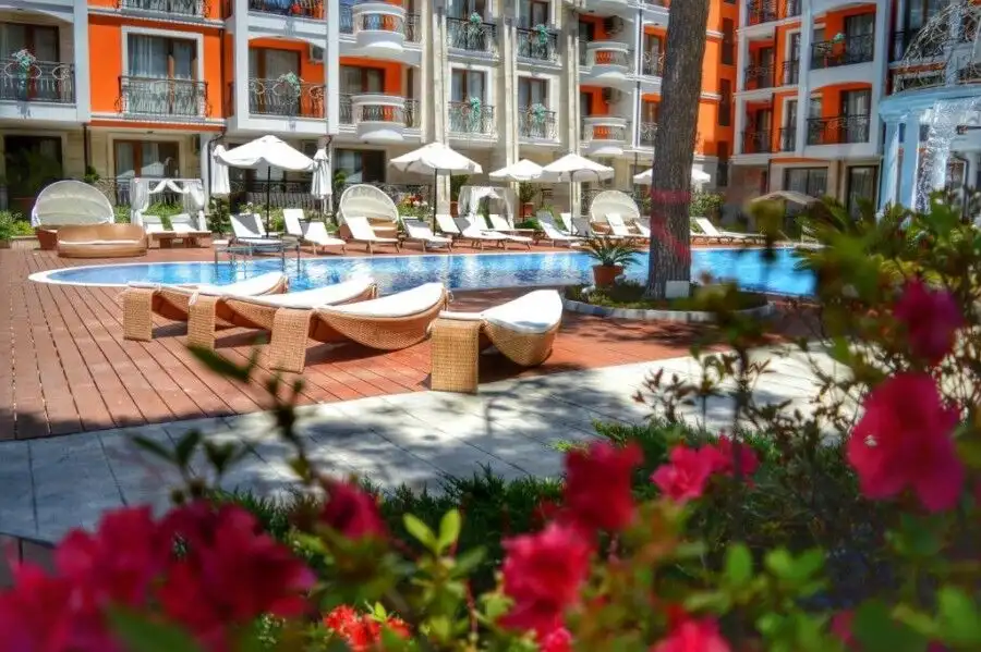 Pool area with sun loungers and umbrellas at Harmony Palace, Sunny Beach.
