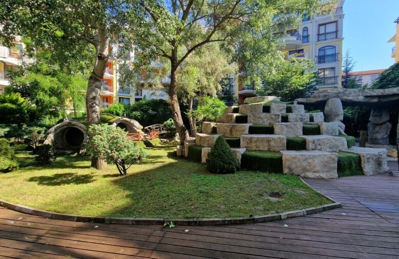 Bright outdoor garden area with lush greenery and modern stone features at Harmony Suites in Sunny B.
