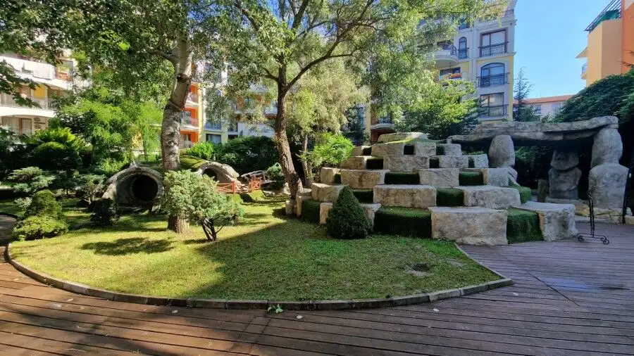 Bright outdoor garden area with lush greenery and modern stone features at Harmony Suites in Sunny B.