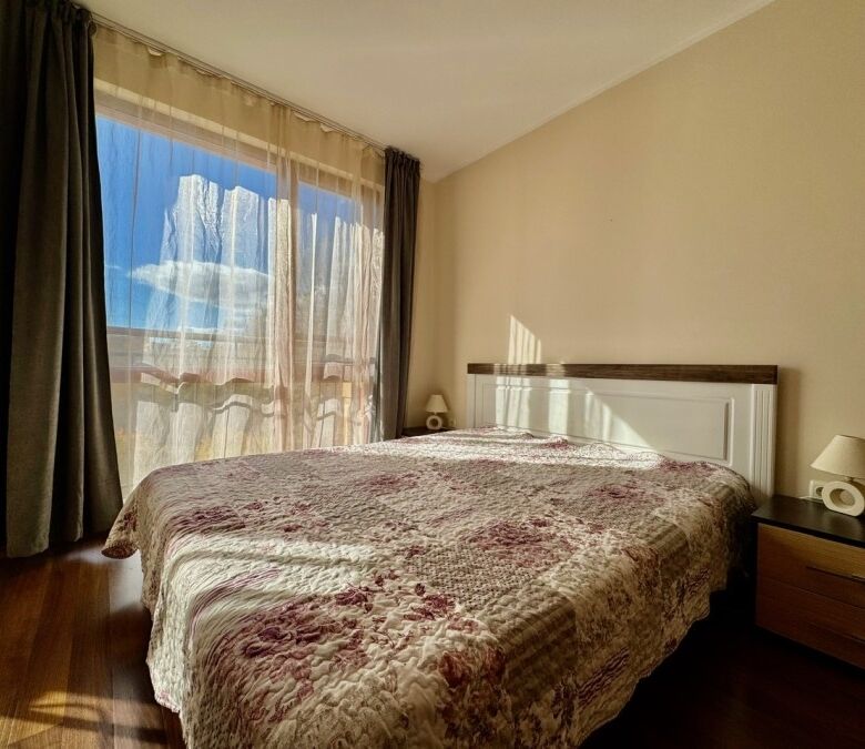 Bright bedroom with large window and sunlight in Sunny Beach resort.