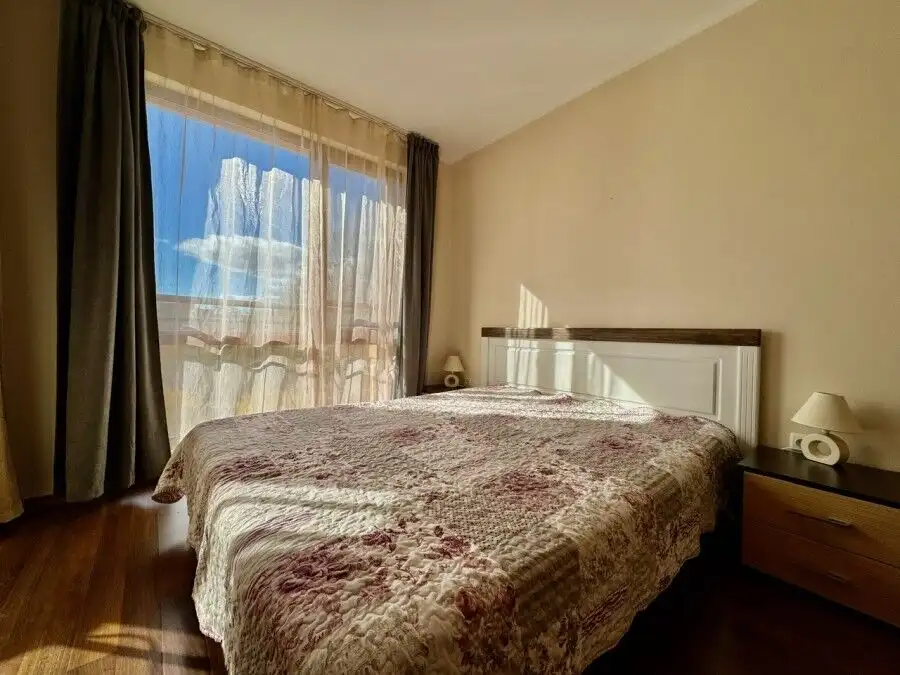 Bright bedroom with large window and sunlight in Sunny Beach resort.