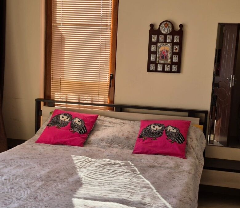 Bright bedroom featuring pink owl pillows and natural light at Cascadas Family Resort.