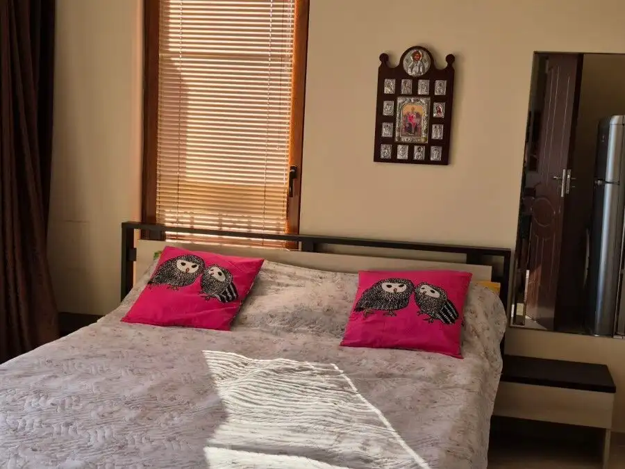 Bright bedroom featuring pink owl pillows and natural light at Cascadas Family Resort.