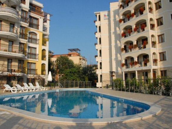 Bright outdoor swimming pool surrounded by residential buildings.
