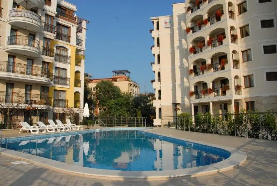 Bright outdoor swimming pool surrounded by residential buildings.
