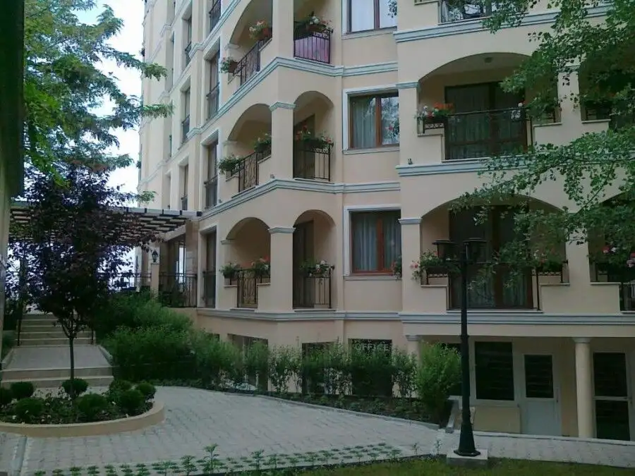 Apartment building with balconies and greenery in Sunny Beach, close to the beach.