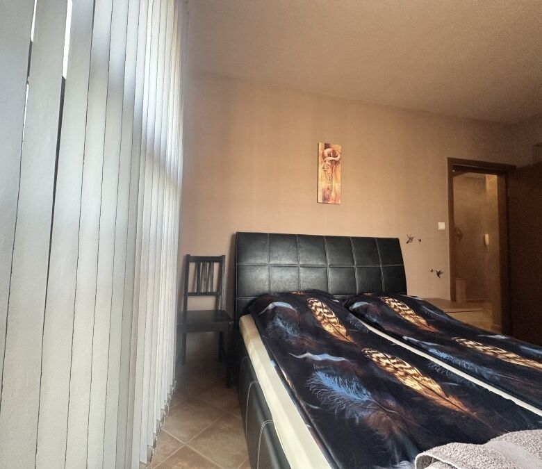 Interior of a bedroom with a large bed and pool view window in Cascadas Family Resort.