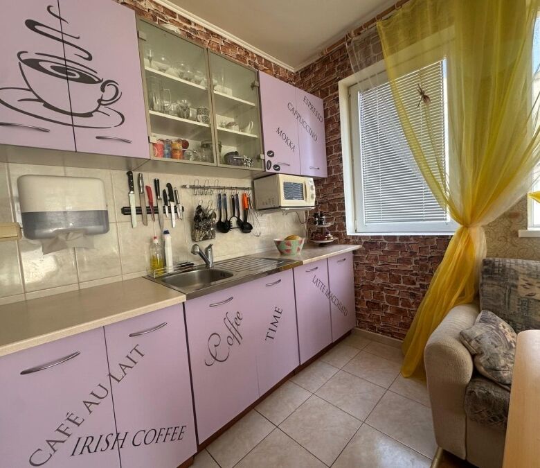 Bright kitchen with purple cabinets and modern appliances in Semiramida Gardens.