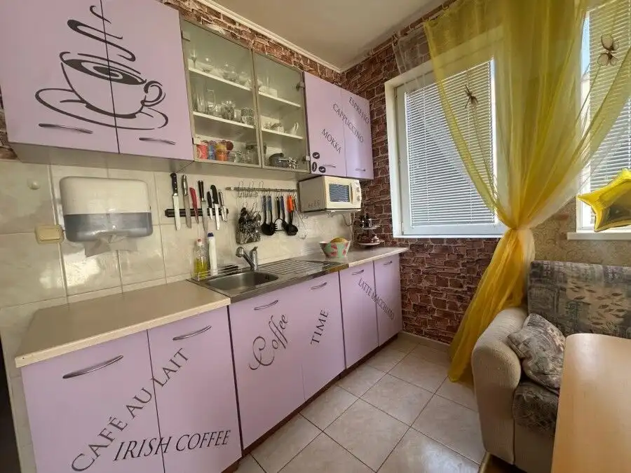 Bright kitchen with purple cabinets and modern appliances in Semiramida Gardens.