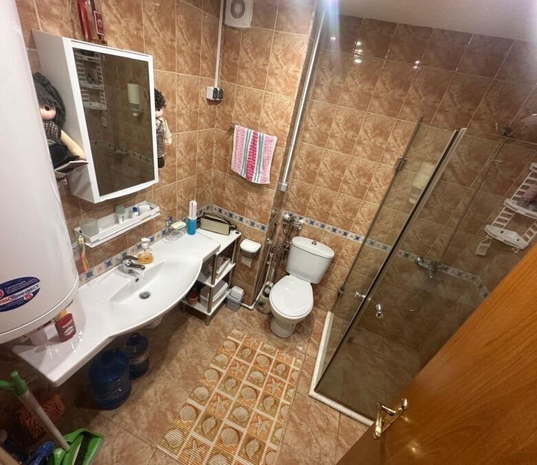 Bright bathroom with shower, toilet, sink, and storage in Semiramida Gardens, Sunny Beach.