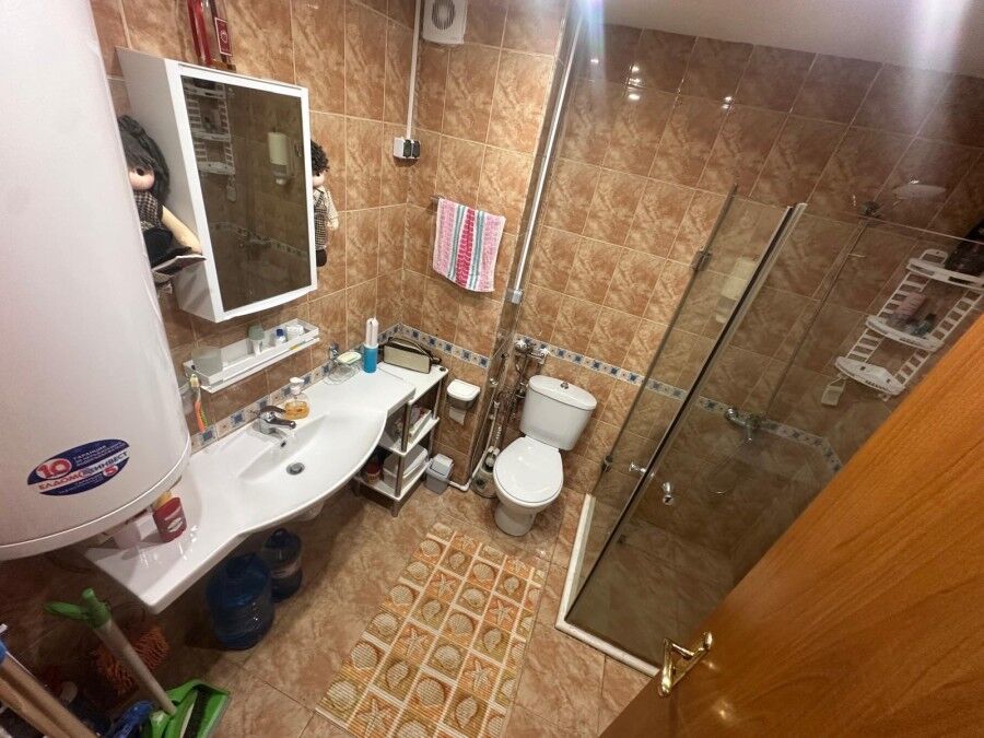 Bright bathroom with shower, toilet, sink, and storage in Semiramida Gardens, Sunny Beach.