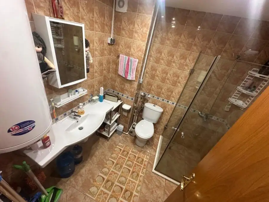 Bright bathroom with shower, toilet, sink, and storage in Semiramida Gardens, Sunny Beach.