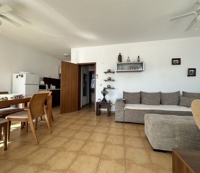 Interior view of a furnished 2-bedroom apartment with a living room, dining area, and modern decor n.