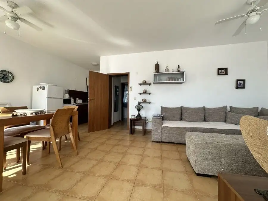 Interior view of a furnished 2-bedroom apartment with a living room, dining area, and modern decor n.