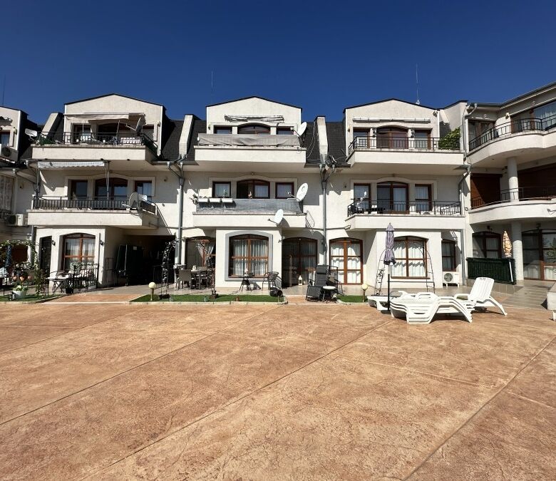 Modern apartment complex with outdoor terrace and seating areas.