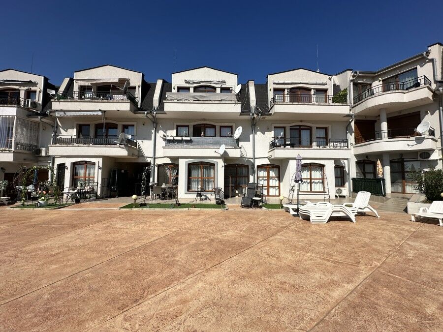 Modern apartment complex with outdoor terrace and seating areas.