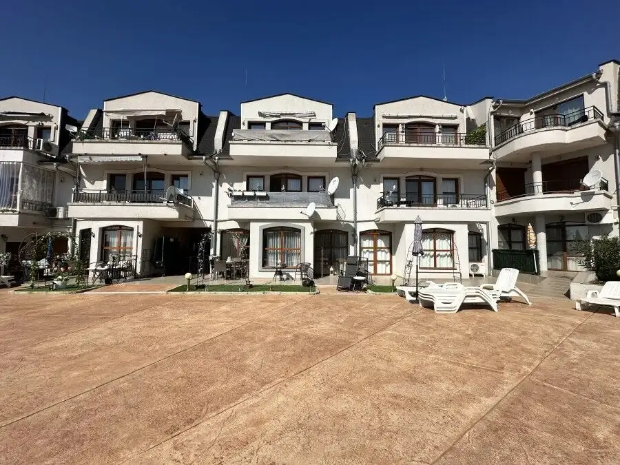 Modern apartment complex with outdoor terrace and seating areas.