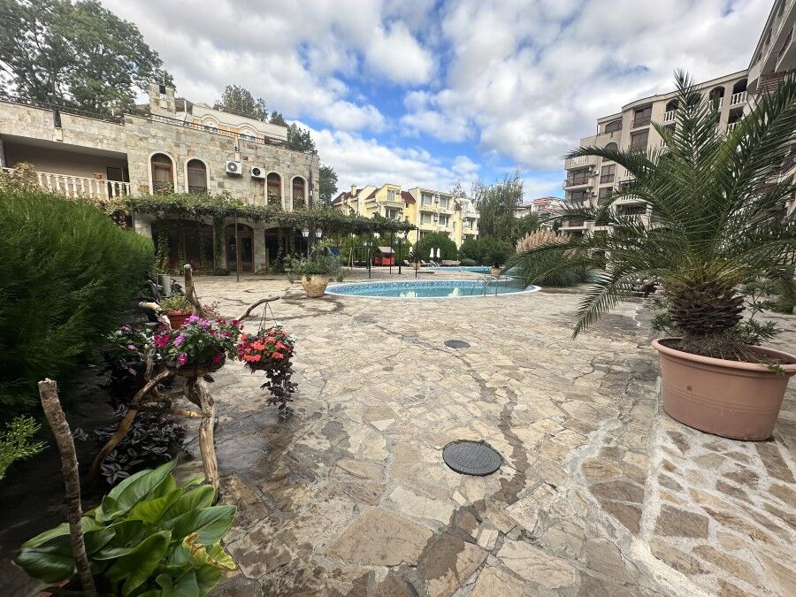 Modern residential complex with pool in Sunny Beach, Bulgaria. Beautiful outdoor pool area surrounded by lush greenery and stylish apartment buildings.