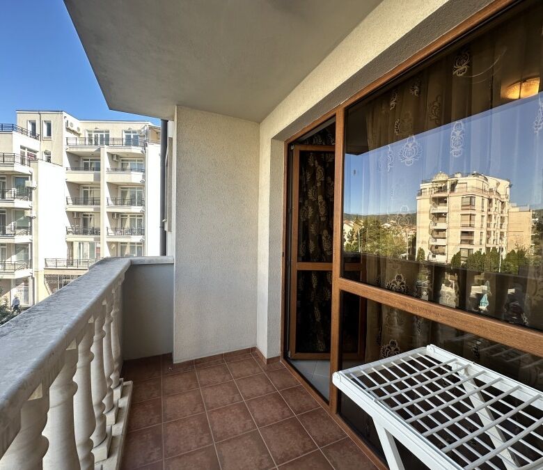 Balcony view of Sunny Beach apartments, 250m from the sea, with cityscape and modern buildings.