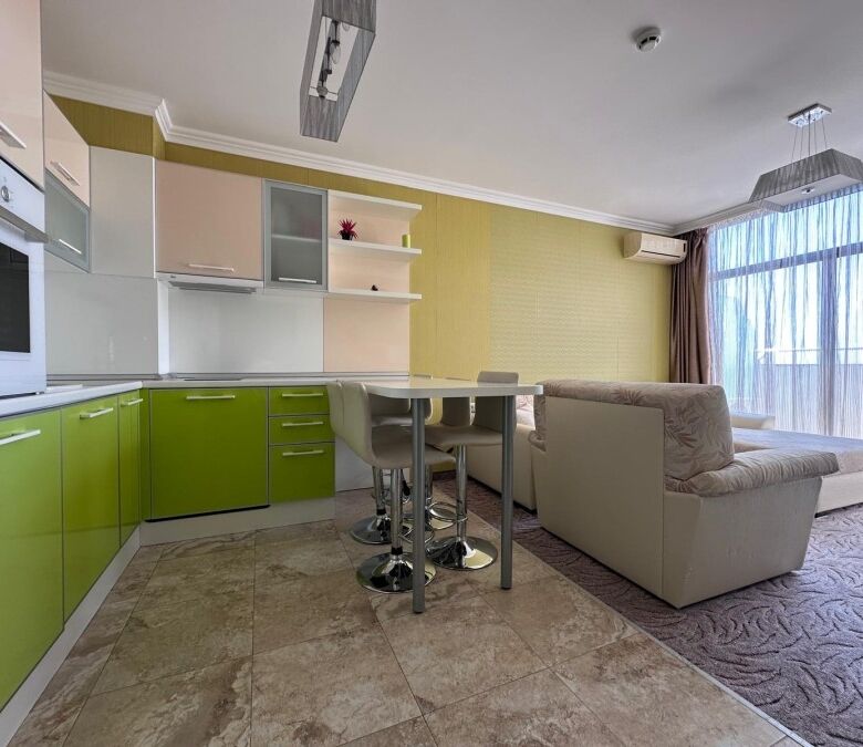 Bright apartment interior with sea views, featuring a cozy living room and modern kitchen.
