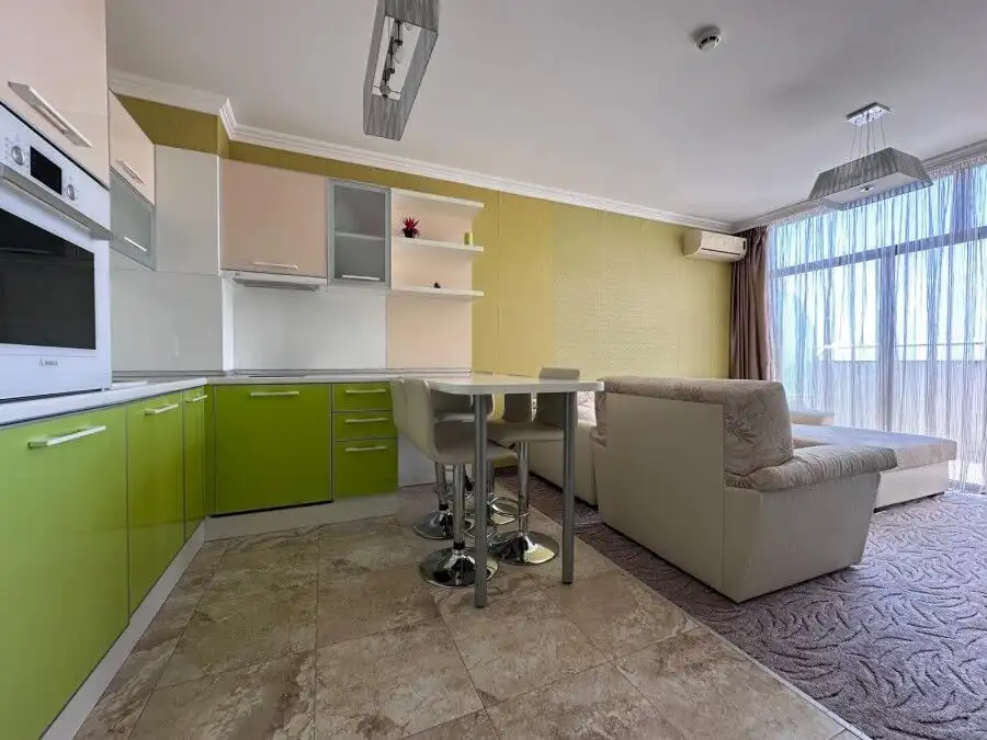 Bright apartment interior with sea views, featuring a cozy living room and modern kitchen.