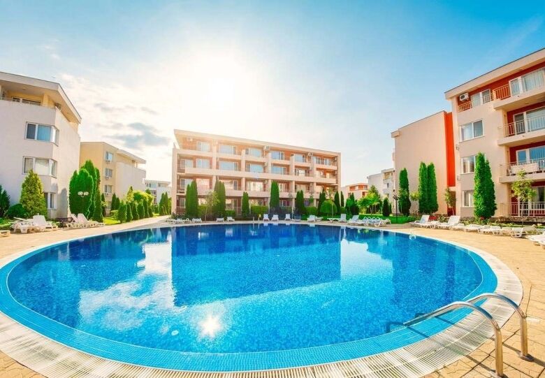 Modern apartment with pool, balconies, and lush surroundings in Nessebar Fort Club.