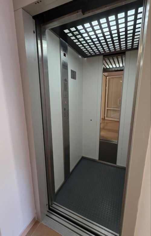 Elevator interior with modern design and safety features.