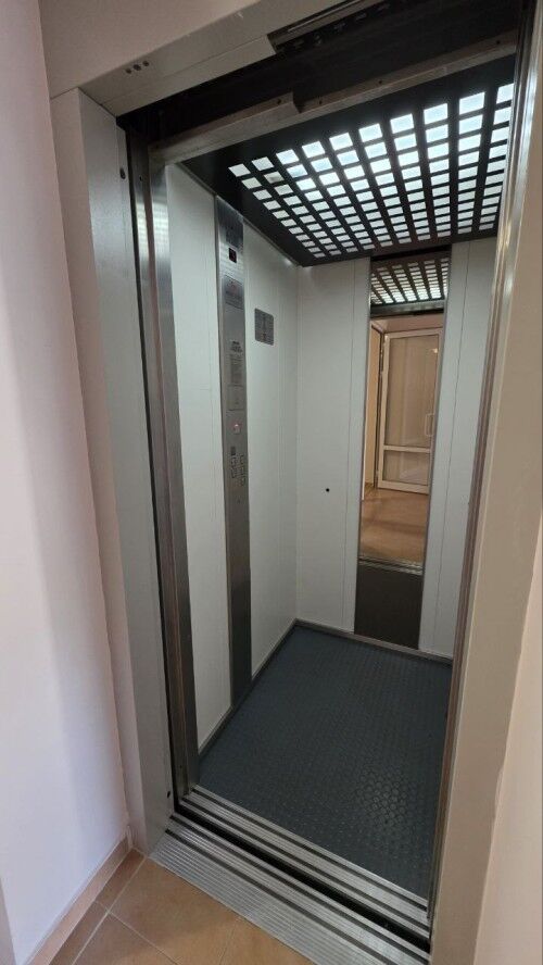 Elevator interior with modern design and safety features.