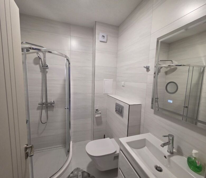 Bathroom with shower, toilet, and sink in a new 1-bedroom apartment in Sunny Beach.