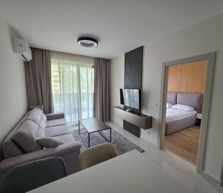 Apartment interior with living room, sofa, TV, and bedroom view in Emilia Romana Verde.