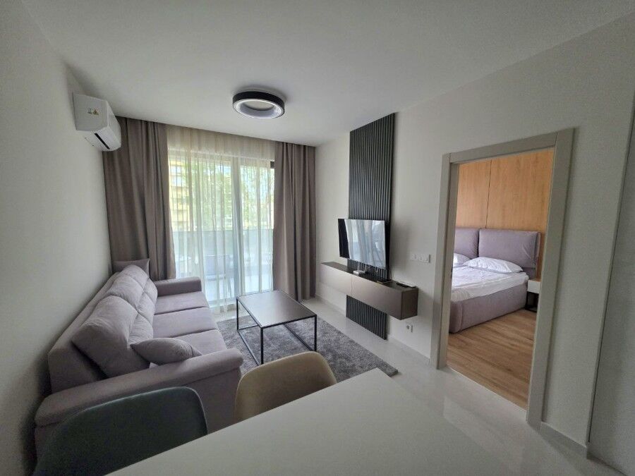 Apartment interior with living room, sofa, TV, and bedroom view in Emilia Romana Verde.