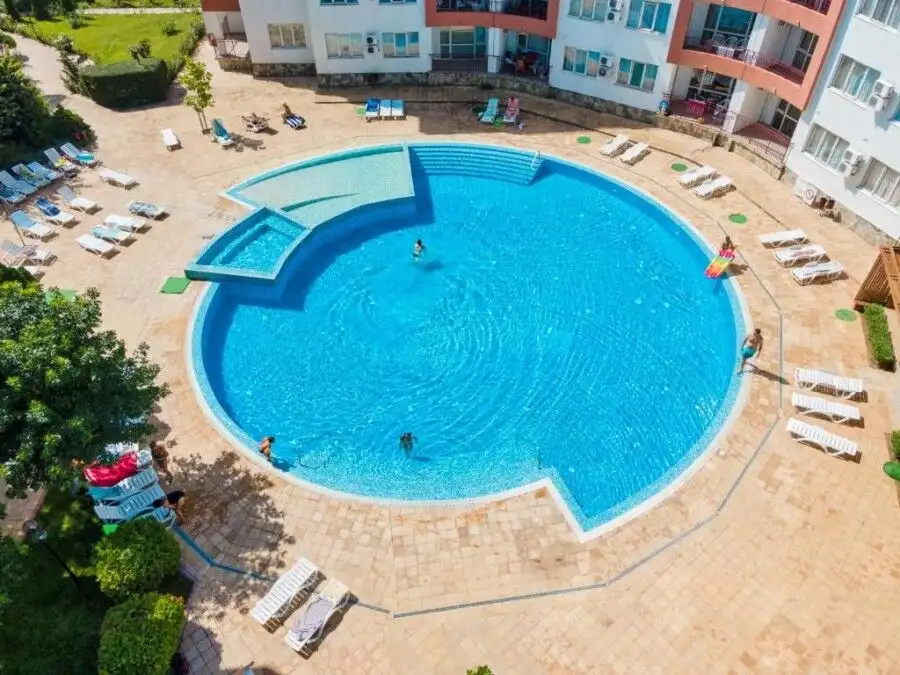 Pool area at Riviera Fort in Ravda with sun loungers and clear blue water.