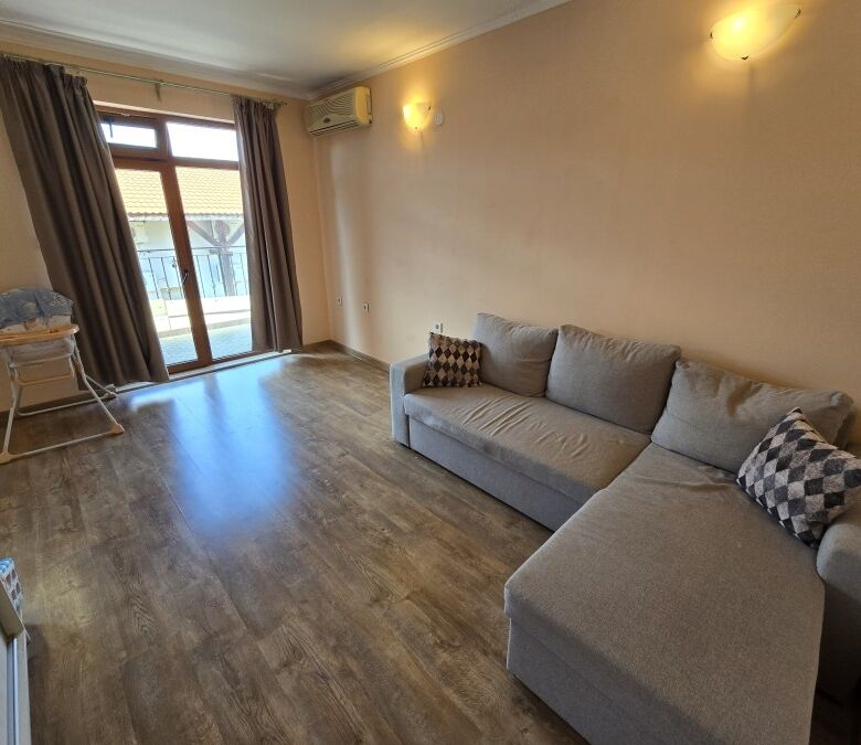 Apartment with living area and balcony near the sea.