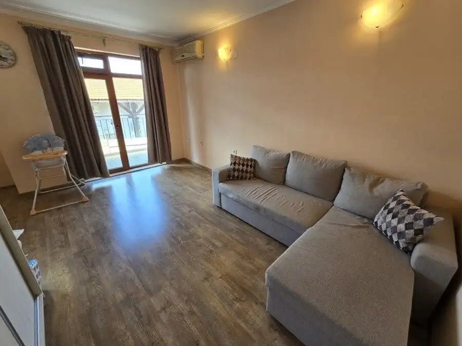 Apartment with living area and balcony near the sea.