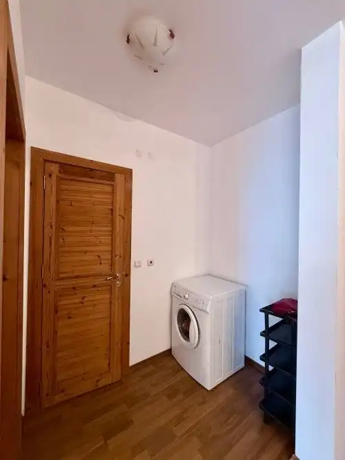 Small laundry area with washing machine and wooden door in Sveti Vlas property.