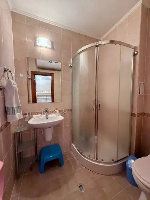 Bright bathroom with shower cabin, sink, mirror, and towel rack in Sveti Vlas property.