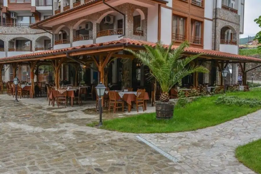 Outdoor dining area with wooden tables and lush greenery in Sveti Vlas, near Olymp. Perfect for rela.