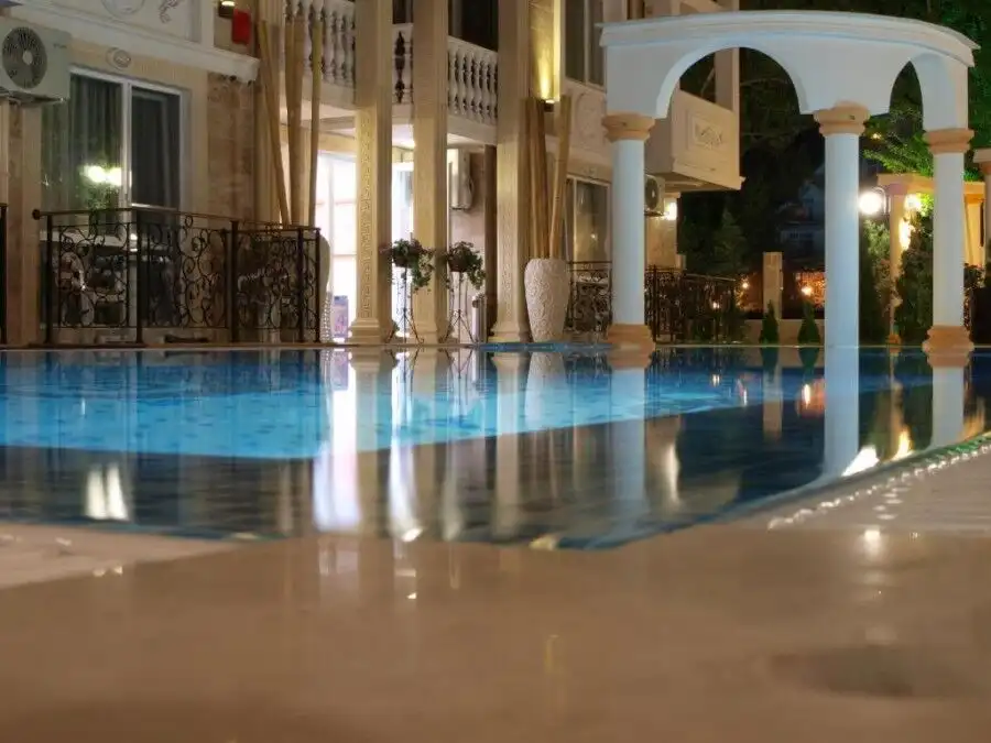 Indoor pool with ornate design, large windows, and stylish furnishings in a top-floor apartment.