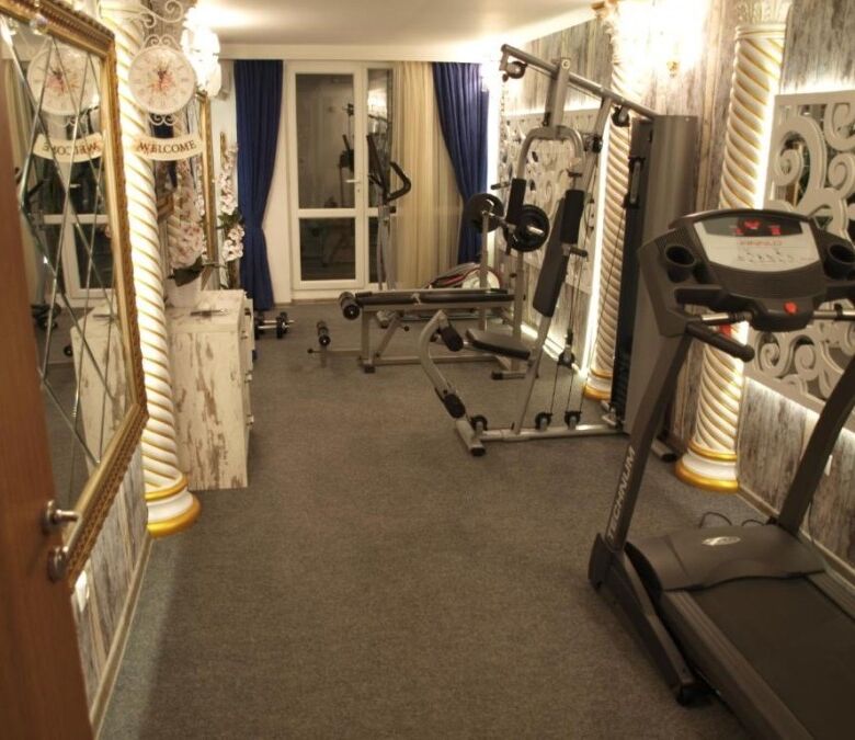 Modern gym with fitness equipment in Sunny Beach apartment.