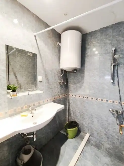 Bright bathroom with modern fixtures and water heater.