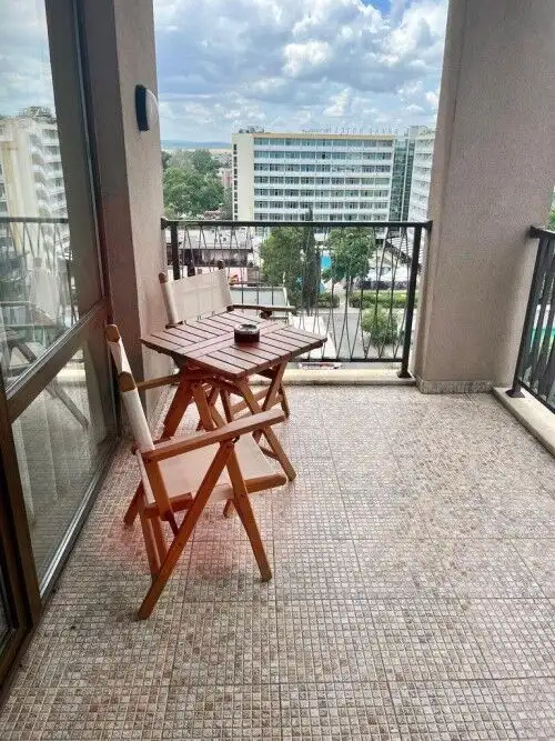 Balcony featuring a small wooden table and chairs overlooking Sunny Beach skyline. Perfect for relax.