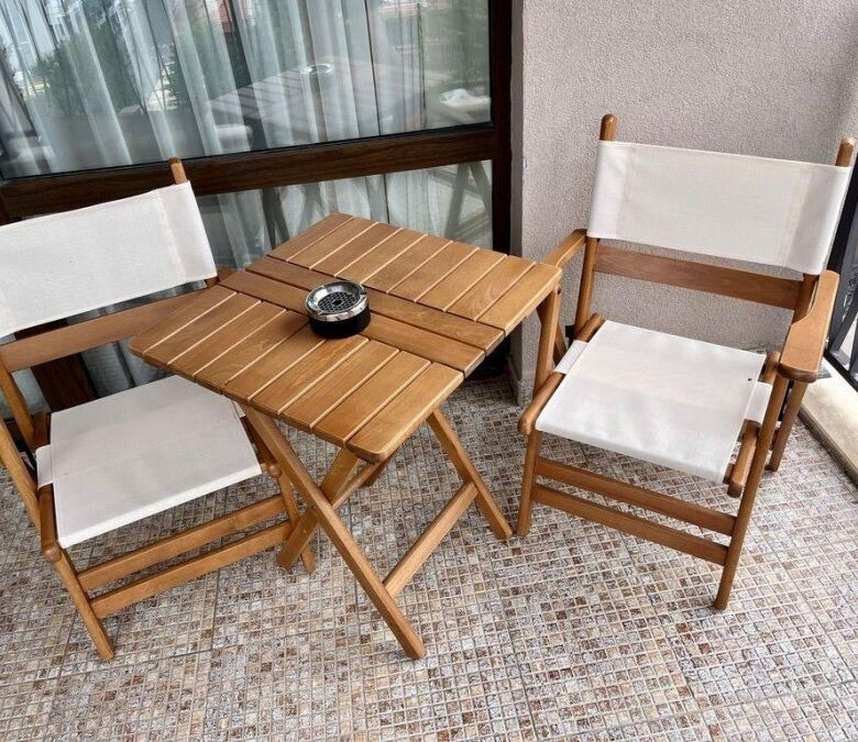 Balcony with two wooden chairs and small table overlooking Sunny Beach.