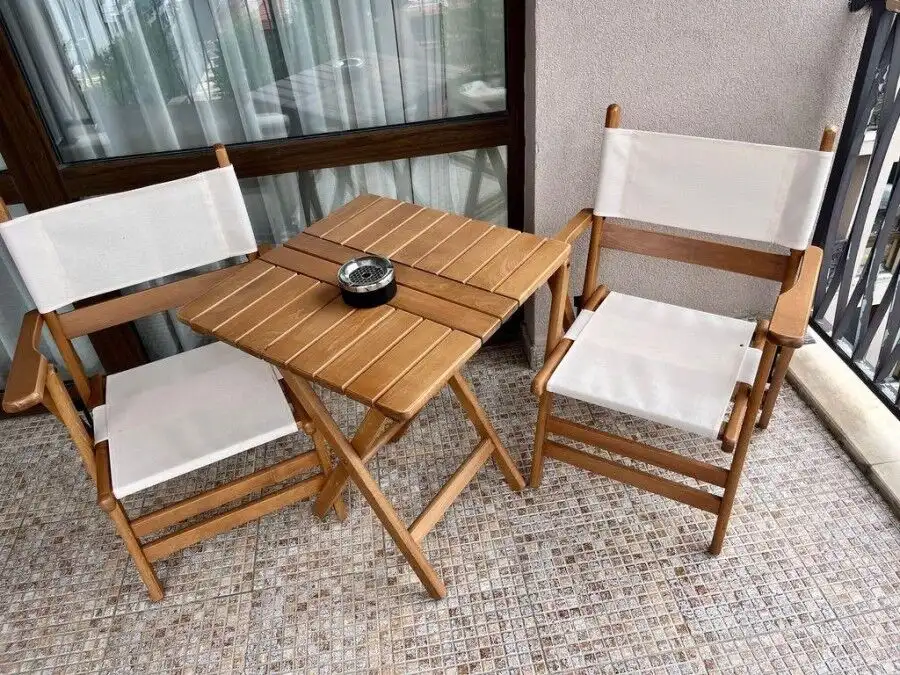 Balcony with two wooden chairs and small table overlooking Sunny Beach.