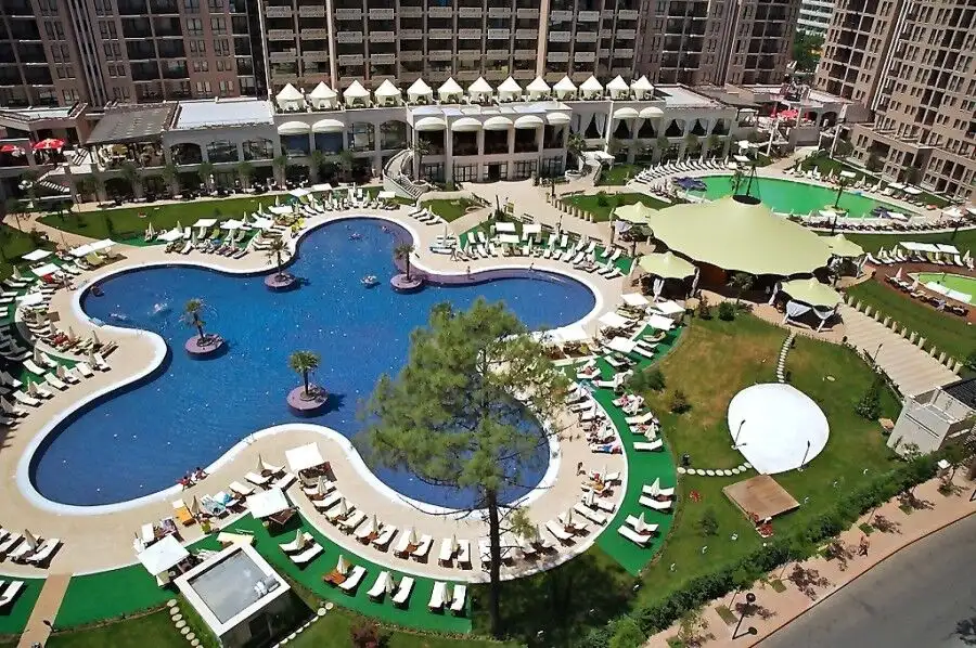 Beautiful aerial view of the spacious swimming pool with sun loungers and lush greenery at Royal Bea.